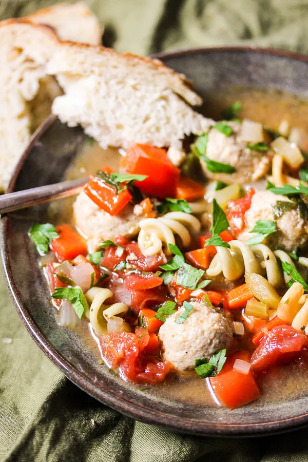 Close up of the soup being served in a bowl along with bread