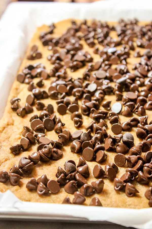 Cookie layer topped with melty chocolate chips before spreading the chocolate out