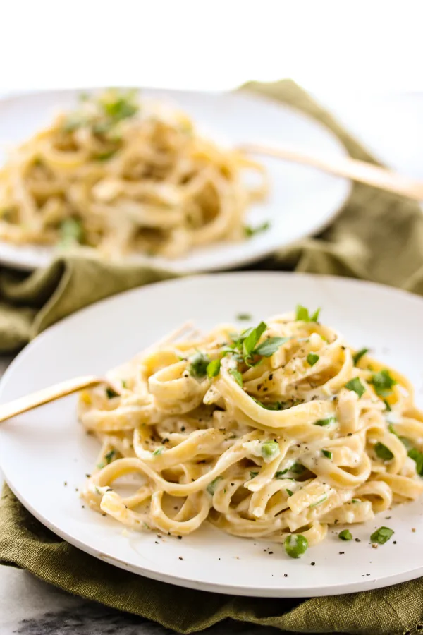 Skinny fettuccine plated with a parsley garnish 