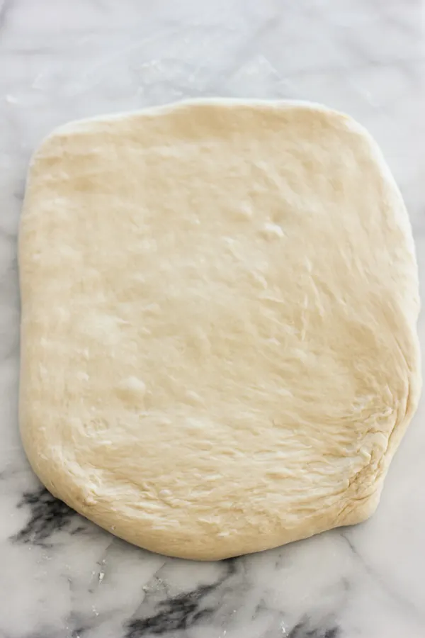 Dough stretched out into a rectangle ready to be made into rolls