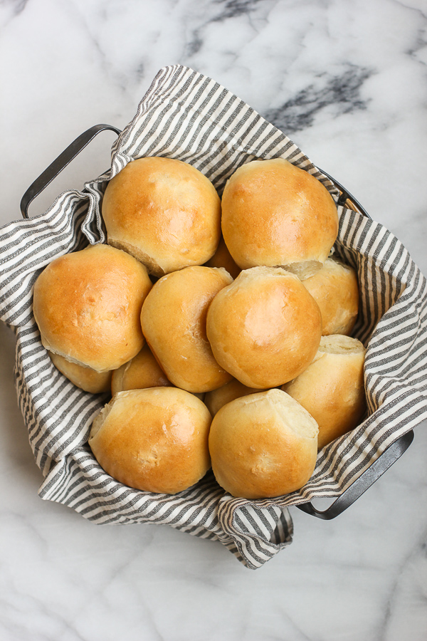 Finished homemade sandwich rolls in a napkin lined basket