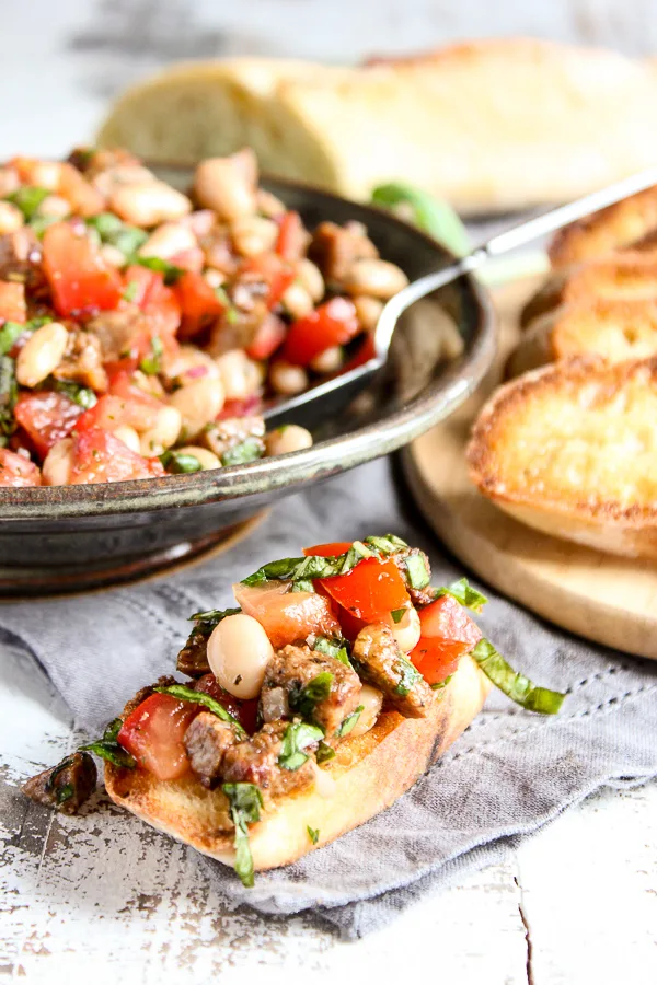 Klement's sausage and white beans combine with traditional bruschetta ingredients to create this mouthwatering Italian sausage and white bean bruschetta.