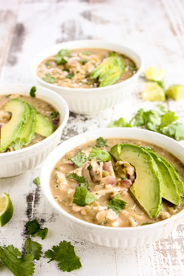 photo of finished white chicken chili garnished with avocado slices.