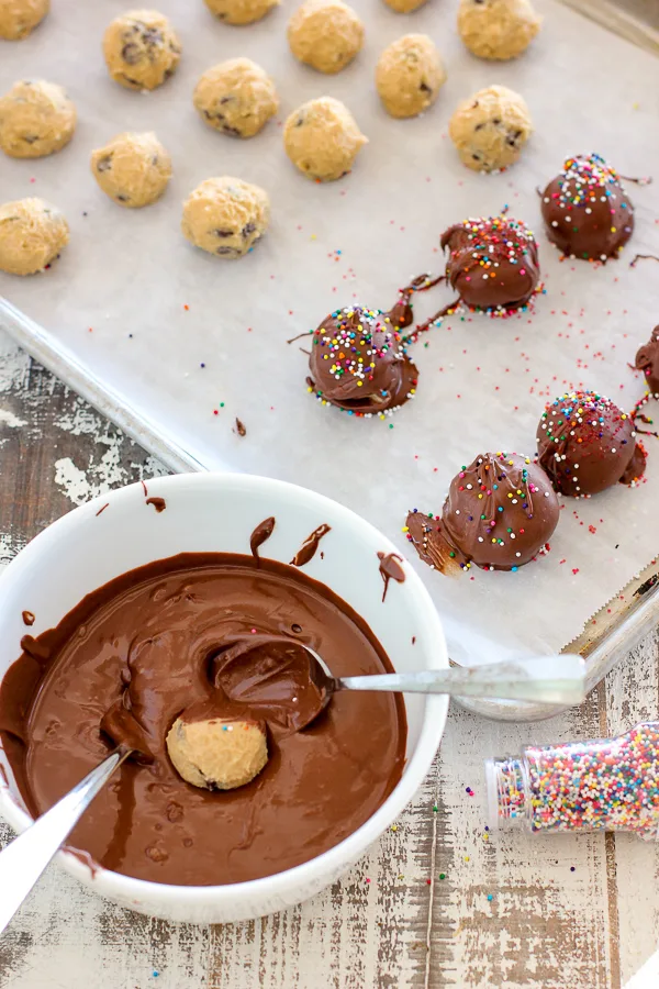 demonstrating how to dip the truffles in the peanut butter chocolate mixture