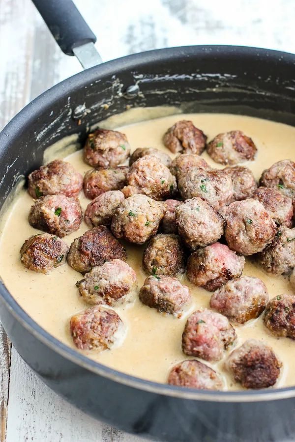 Browned meatballs in the the cream sauce to finish cooking