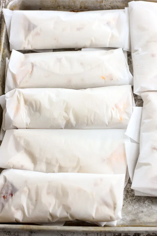 Breakfast burritos wrapped in parchment ready for the freezer