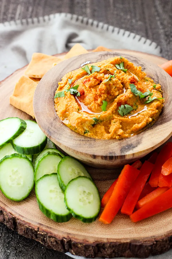Easy Pumpkin Hummus in a serving bowl with fresh veggies and pita chips