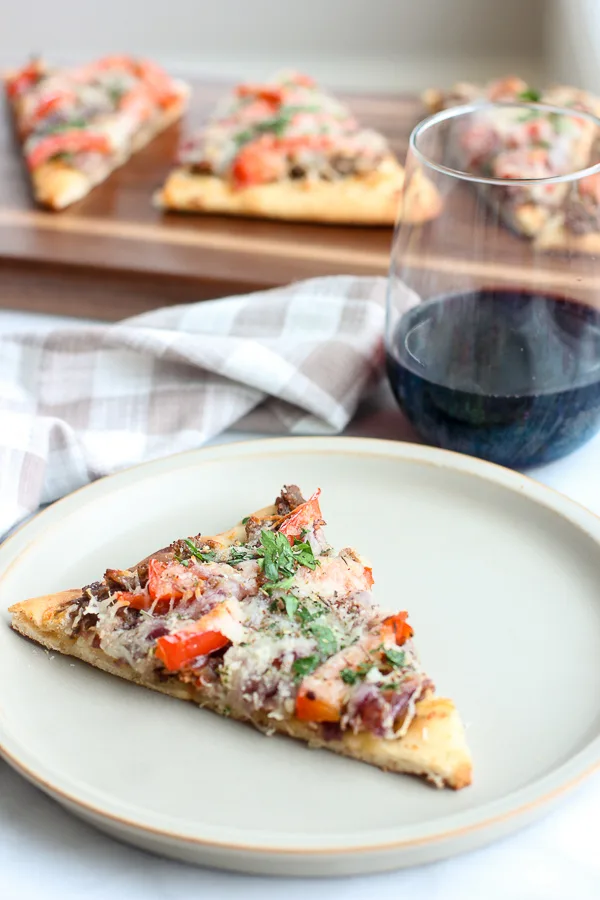 slice of flatbread served with a glass of wine with flatbread slices in the background