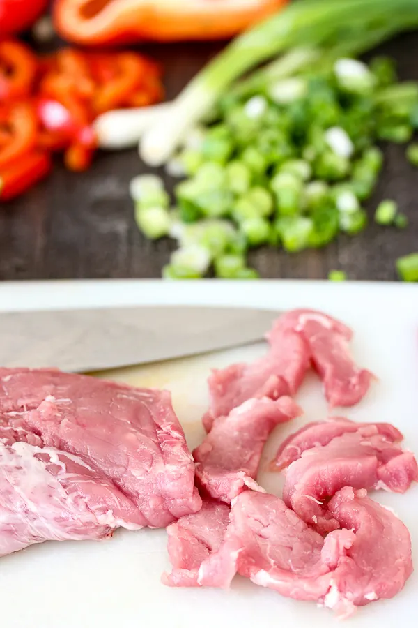 Slicing the pork tenderloin into thin strips
