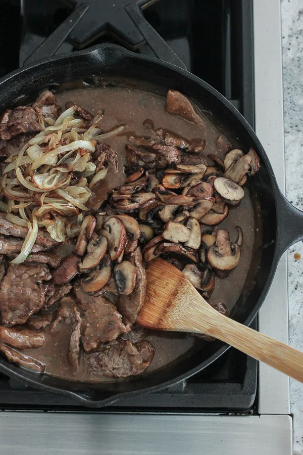 Sautéed Mushrooms and onions getting mixed into the sauce with the sautéed steak.