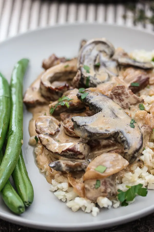 Plate of skillet beef stroganoff over rice with green beans - close up photo