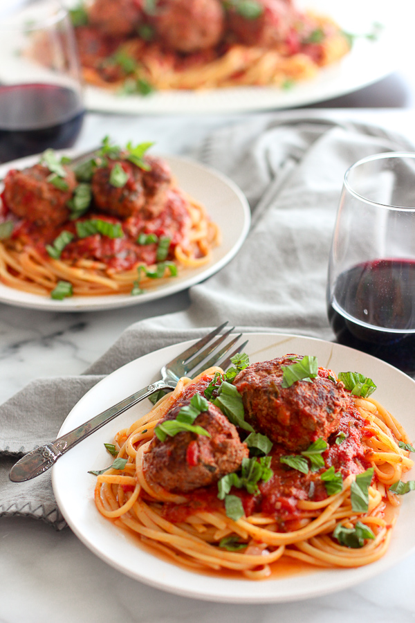 Spaghetti and meatballs plated and served with wine