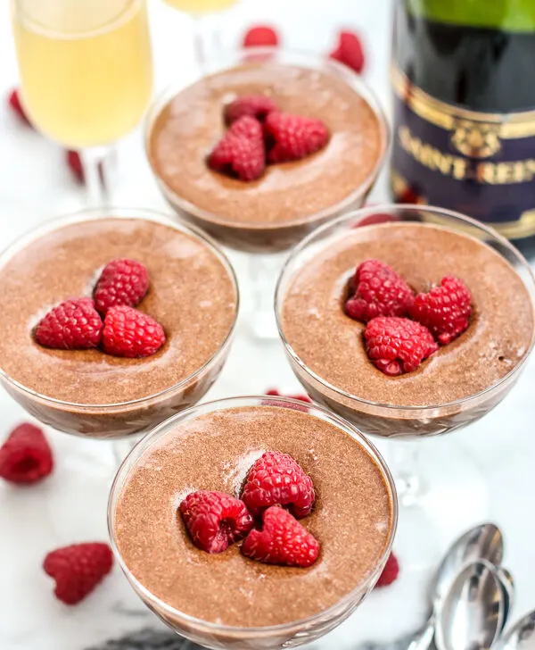 four martini glasses with chocolate mousse topped with strawberries