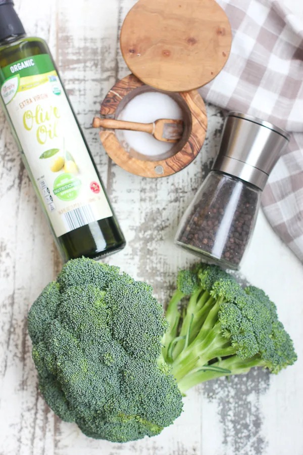 Ingredients needed to make roasted broccoli. Olive oil, salt, pepper and broccoli