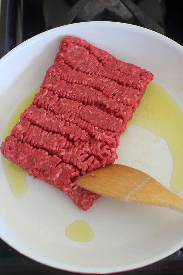 The ground beef in the skillet with olive oil before breaking up and blowing