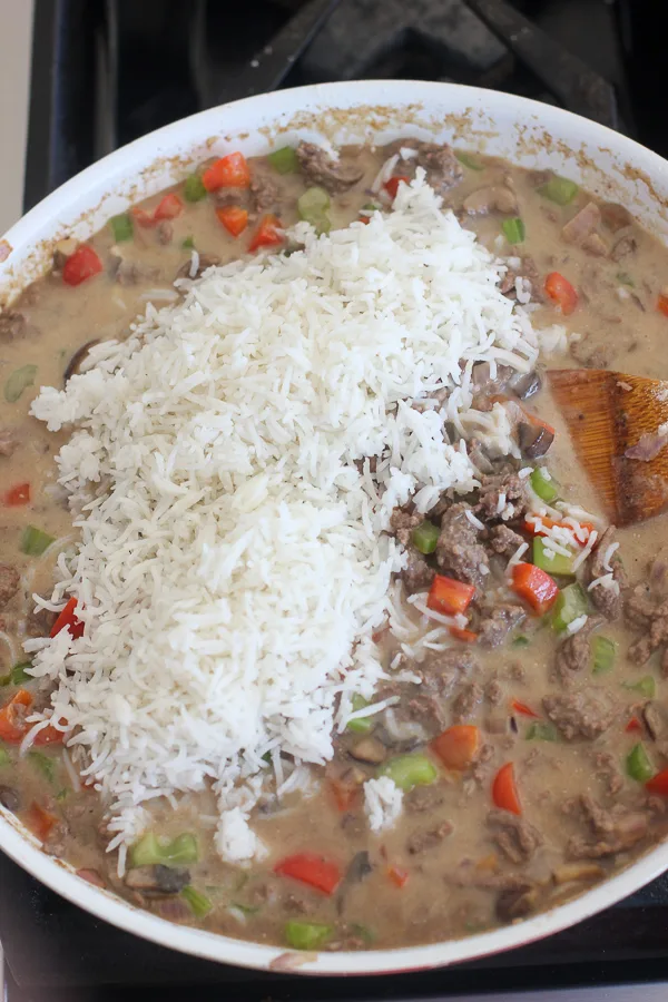 The white rice being added to the skillet