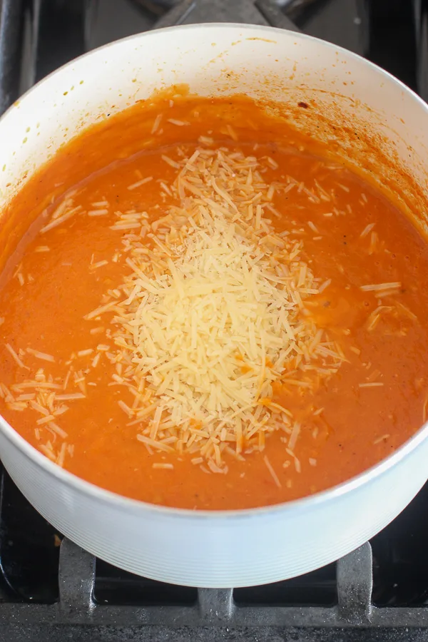 Adding the parmesan cheese to the soup