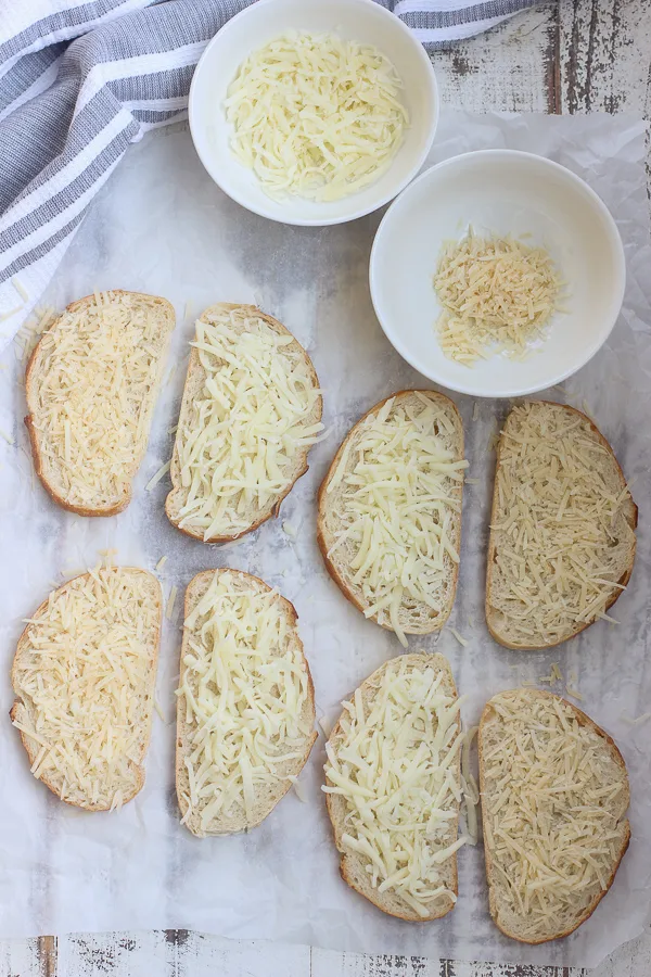 Bread has been buttered and cheese has been added, before cooking