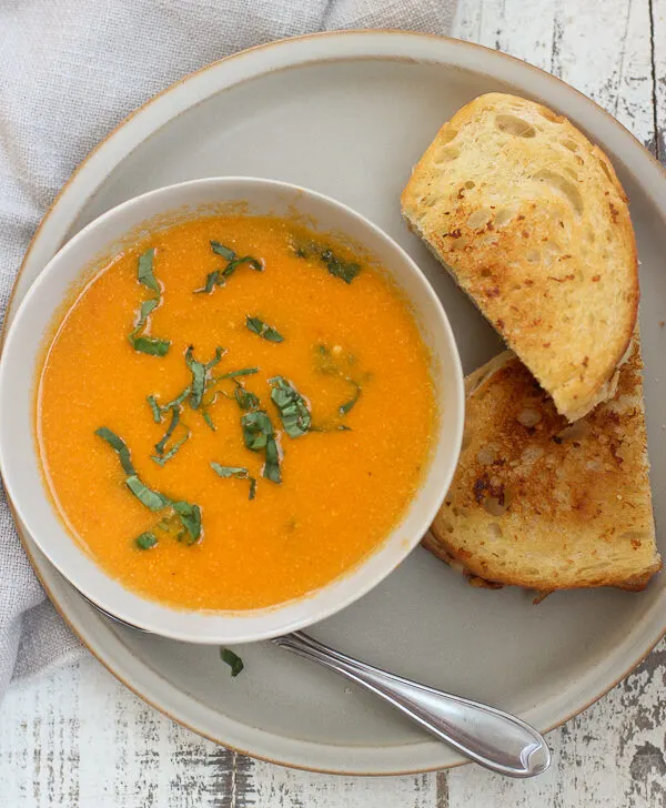 Overhead photo of soup and sandwich served on a plate