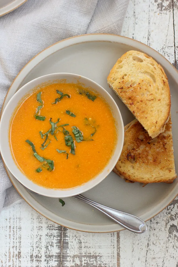 Overhead photo of soup and sandwich served on a plate